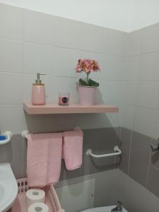 a bathroom with pink towels and a toilet and a shelf at Kannon 1 in Caparica +5 photos