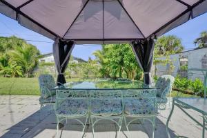 a glass table and chairs under a purple umbrella at Villa Riviera Beach -4Bdr Relaxing Retreat By Viac in Riviera Beach