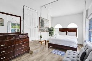 a bedroom with a bed and a dresser and a mirror at Villa Riviera Beach -4Bdr Relaxing Retreat By Viac in Riviera Beach