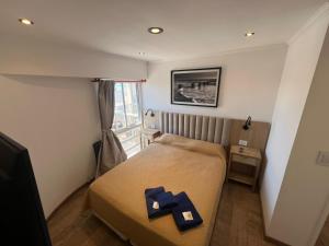 a small bedroom with a bed with a blue cross on it at Chiara's Apartament panoramico in Santa Teresita