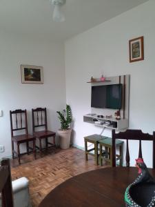 a living room with a table and chairs and a television at Recanto aconchegante próximo ao mar in Vila Velha