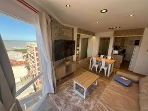 a living room with a large window with a view of the ocean at Chiara's Apartament panoramico in Santa Teresita