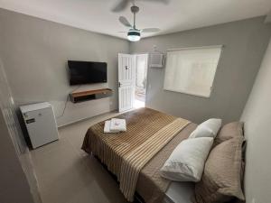 a bedroom with a bed and a flat screen tv at Cantinho da Ilha Suites in Abraão
