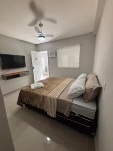 a bedroom with a bed and a ceiling fan at Cantinho da Ilha Suites in Abraão