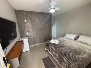 a bedroom with a bed and a flat screen tv at Cantinho da Ilha Suites in Abraão