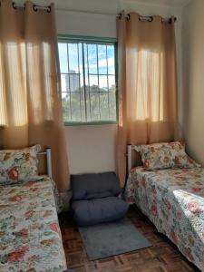 a room with two beds and a window at Recanto aconchegante próximo ao mar in Vila Velha