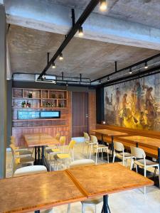a restaurant with wooden tables and chairs and a painting at Althia Capsule Quarters in Badung