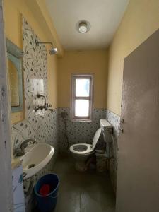 a bathroom with a sink and a toilet and a window at Hotel Pokhara Peace in Kathmandu