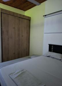 una cama en una habitación con puerta de madera en Hospedaje LunaDorada en Doradal, en Puerto Triunfo 14 fotos más