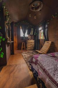 een slaapkamer met een bed en een stoel in een kamer bij Trini Treehouse By GEstores in Huasca de Ocampo