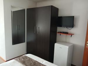 a bedroom with a black cabinet and a television at Moshitametsi Guesthouse in Kempton Park