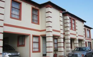 a building with cars parked in front of it at Moshitametsi Guesthouse in Kempton Park