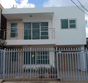 a white house with a white fence at Apartamento la Isla 2-Coveñas in Coveñas