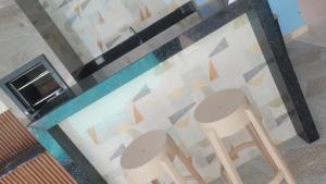 a pair of chairs sitting in front of a wall at Aquarela do Sertão in Piranhas