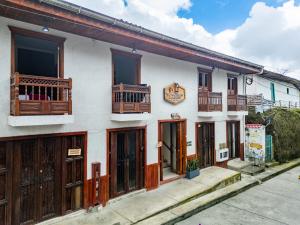 a white building with wooden doors and balconies at Mi Balconcito in Salento