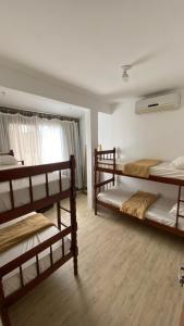 enseada hostel في غوارويا: غرفة نوم بها سريرين بطابقين ونافذة