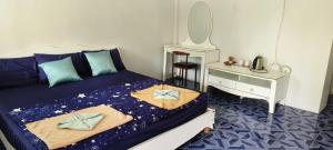 a bedroom with a bed with blue sheets and a desk at Kohmook cocobeach in Ko Mook