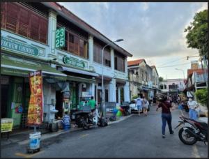 a group of people walking down a street with buildings at Loke Thye Kee Heritage Hotel, Georgetown Penang in George Town