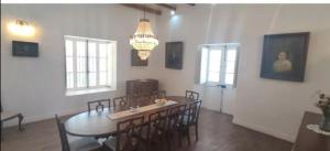 a dining room with a table and chairs and a chandelier at Casona Starlight in Melipilla
