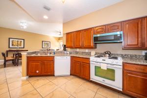 eine Küche mit Holzschränken und einem weißen Herd mit Backofen in der Unterkunft Pura Vida a Private Master Bedroom with shared living space in Orlando