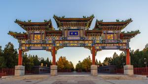 a large gate in a park with a building at Chinese Culture Boutique Hotel TangFu, Liangma Riverside, Near Sanlitun & Embassy Area, Metro Access, 20min to Wangfujing, Forbidden City & Tian'anmen Square, Airport & the Great Wall Travel Assistance in Beijing