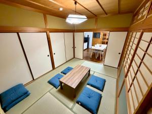 an empty room with a table and blue chairs at Nomad Kumano in Nachikatsuura