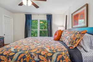 a bedroom with a bed with a comforter and a window at Trailblazer Lodge - Upscale, hot tub, trail, game room, wifi, fire pit, bar, pool table, king bed, view, pet friendly in Berkeley Springs