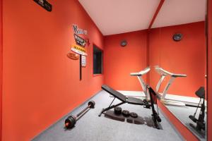 an orange gym with two exercise bikes in a room at Beijing TangFu Chinese Culture Boutique Hotel Sanlitun Embassy Area in Beijing