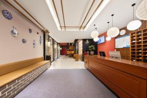 a corridor of a restaurant with a counter and pendant lights at Beijing TangFu Chinese Culture Boutique Hotel Sanlitun Embassy Area in Beijing