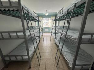 a hallway with four bunk beds in a dorm room at 3 min da Praia de Copacabana - Apartamento Compartilhado PR in Rio de Janeiro