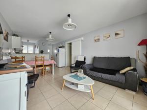 een woonkamer met een bank en een tafel bij Maisonnette proche du bourg, 5 pers, jardin - FR-1-476-84 in LʼAiguillon-sur-Mer