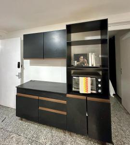 205 Atlântico Residence Vista Mar في فورتاليزا: مطبخ مع خزائن سوداء وميكروويف