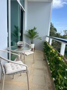 a balcony with a glass table and two chairs at Apartment Karon SeaView 72 sq in Karon Beach