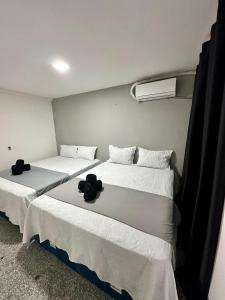 205 Atlântico Residence Vista Mar في فورتاليزا: سريرين في غرفة مع ملاءات بيضاء +10 صور