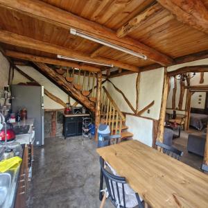 a kitchen and dining room with wooden ceilings and a wooden table at Refugio de montaña OM in Santiago +11 photos