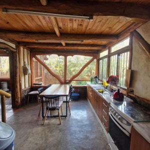 a kitchen with a table and chairs in a cabin at Refugio de montaña OM in Santiago