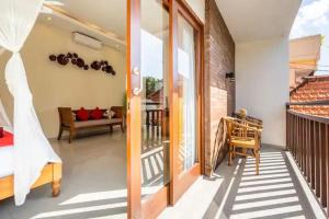 a room with a balcony with a bed and a glass door at Red Lotus Seminyak Villa in Seminyak
