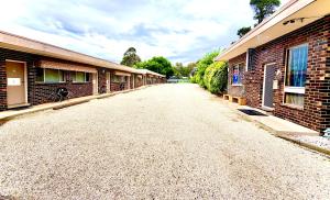 an empty road between two brick buildings at Tartan Motel, Yea in Yea
