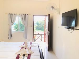 a bedroom with two beds and a flat screen tv at Naraya Homestay in San Pa Tong
