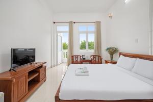 a bedroom with a large bed and a television at Nhà Khách 683 - Only 10m to Mikazuki - 50m to the Beach in Da Nang