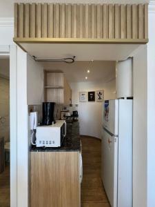a kitchen with a counter top with a microwave and a refrigerator at Chiara's Apartament panoramico in Santa Teresita