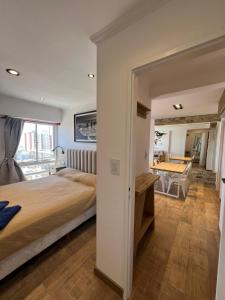 a bedroom with a bed and a table in it at Chiara's Apartament panoramico in Santa Teresita