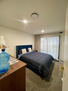 クロムウェルにあるModern Ensuite Room with Light Kitchenette & Private Entrance in Cromwellの青いベッドと窓のある寝室