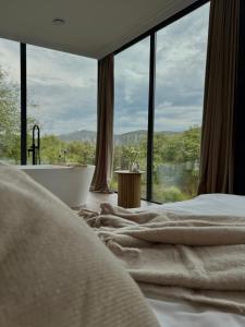 a bedroom with a tub and a large window at Nest House in Dubova