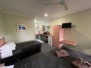 Una habitación de hotel con una cama y una cocina. en Yungaburra Park Motel, en Yungaburra