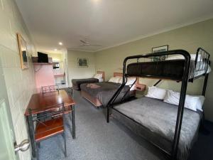 una habitación con dos literas y un escritorio en Yungaburra Park Motel, en Yungaburra