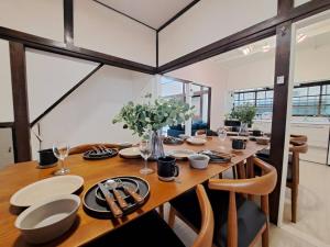 a dining room with a wooden table and chairs at 不入斗-横須賀の大型一棟貸し-最大25人-家族団体向け in Yokosuka +32 photos