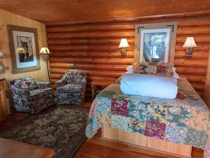 a bedroom with a bed and a chair in a cabin at Laughing Horse Lodge in Bigfork