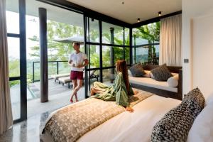 MAUA Nusa Penida Bali في نوسا بينيدا: رجل وامرأة يقفان في غرفة بسرير