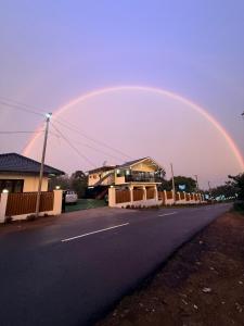 un arco iris en el cielo sobre una calle en Kenza Retreat, en Vagamon